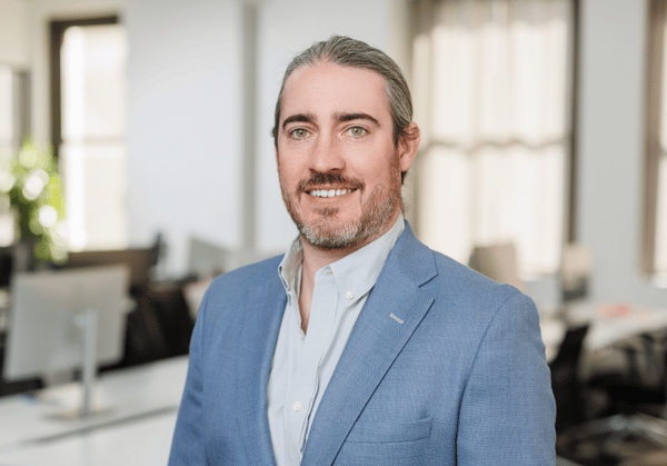 Headshot of Brett Davis with empty office environment in background.