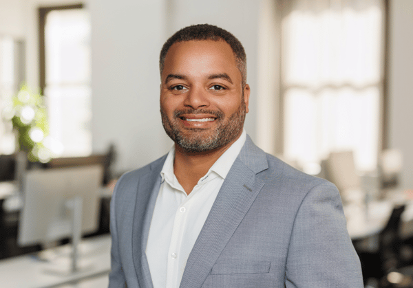 Headshot of Daniel Leslie with empty office environment in background.