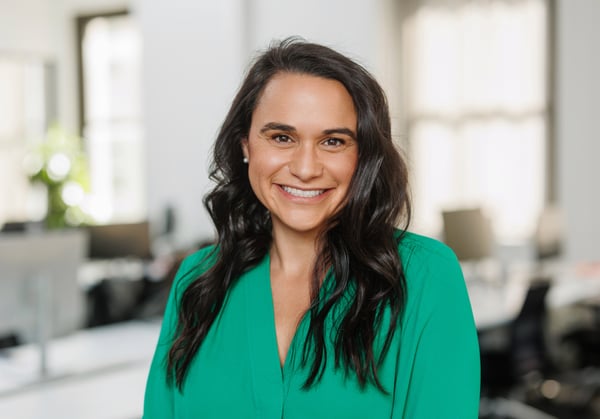 Headshot of Denise Anema with empty office environment in background.