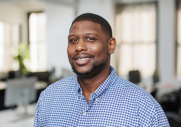Headshot of Raymond King with empty office environment in background.