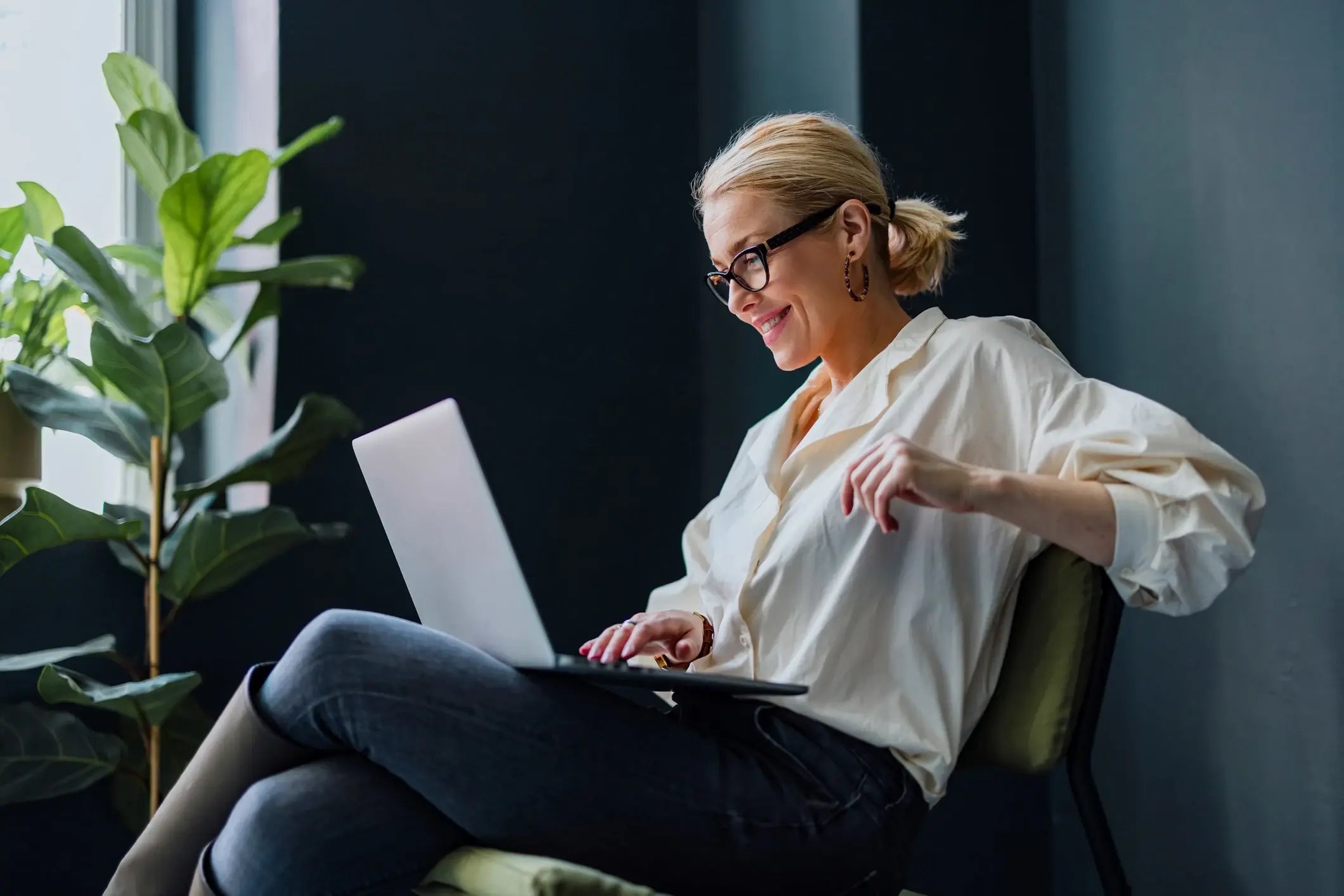 A woman working on her laptop in a modern office
